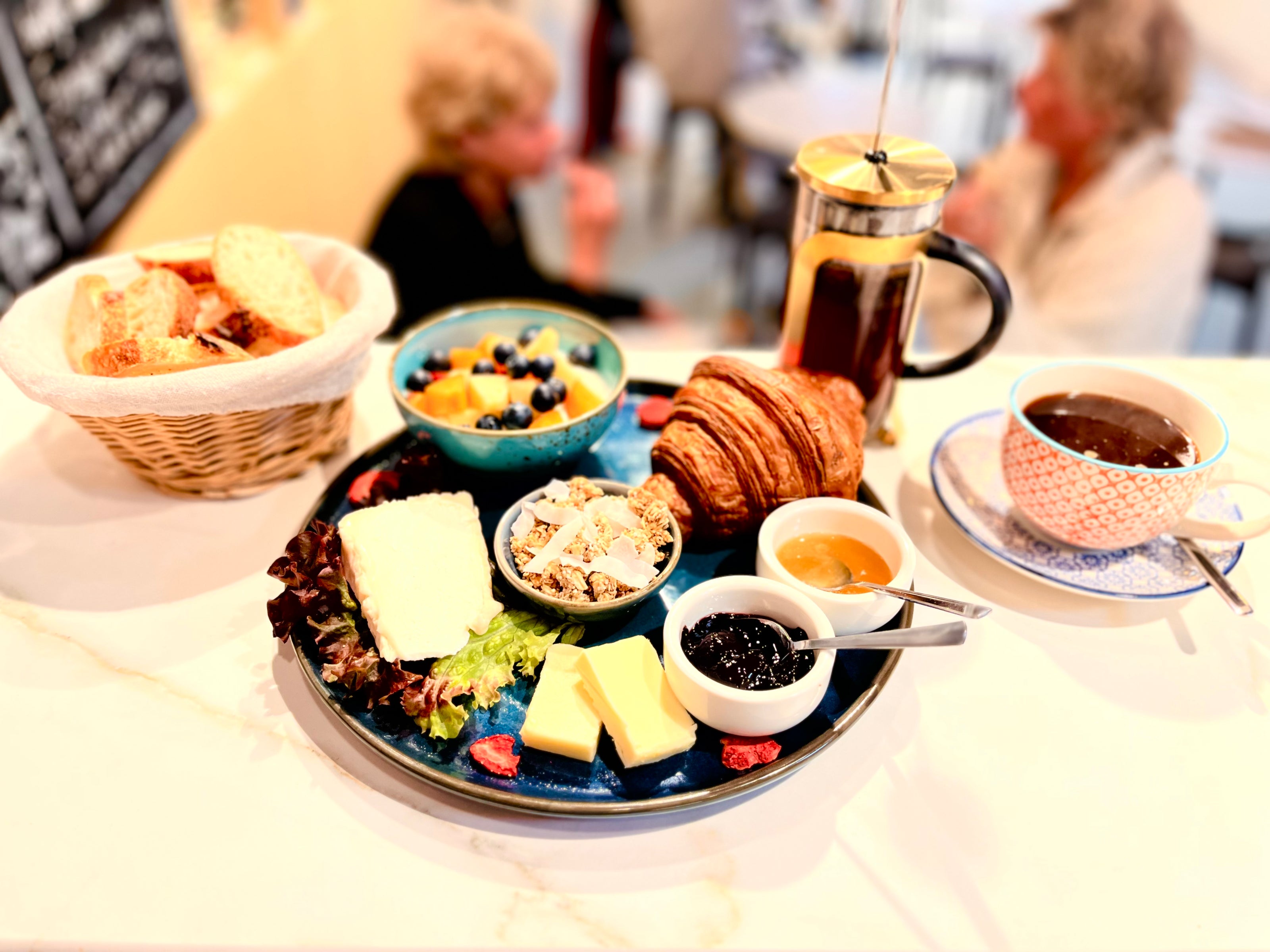Frühstücksteller mit Croissant und Kaffee im Bistro von Les Epicuriens in Berlin-Kreuzberg